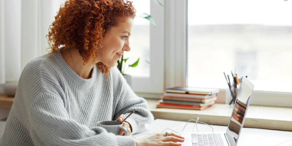 Frau schaut ein Tutorials über CRM, CPQ und AIA am Laptop