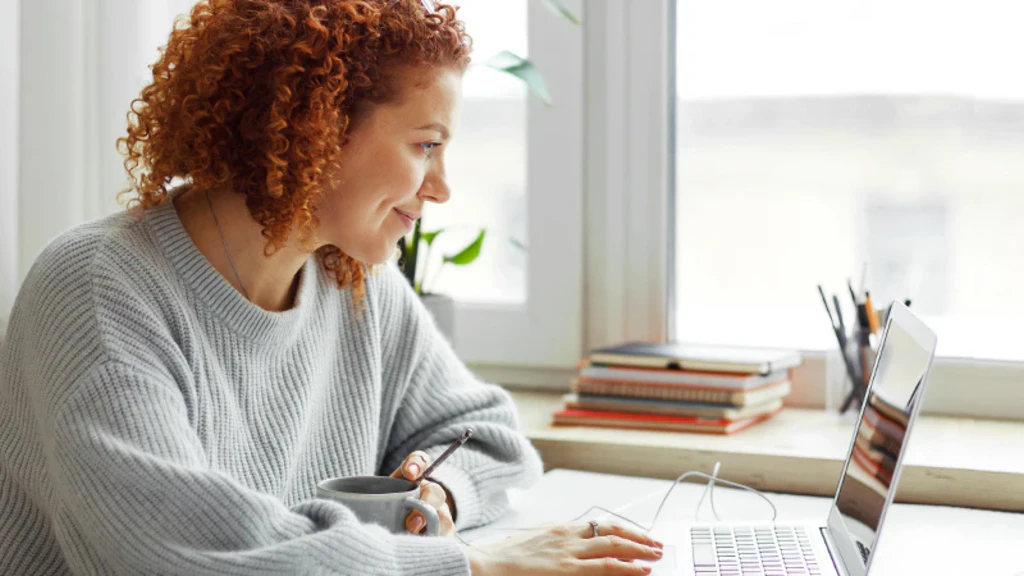 Frau schaut ein Tutorials über CRM, CPQ und AIA am Laptop