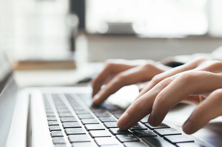 Person verfasst E-Mail am Laptop