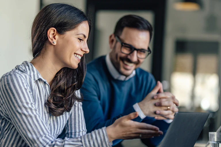 Zwei Personen checken Daten am Laptop