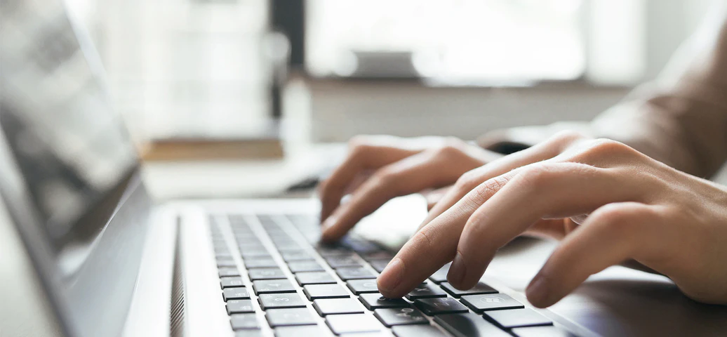 Person verfasst E-Mail am Laptop