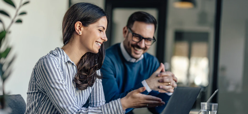 Zwei Personen checken Daten am Laptop